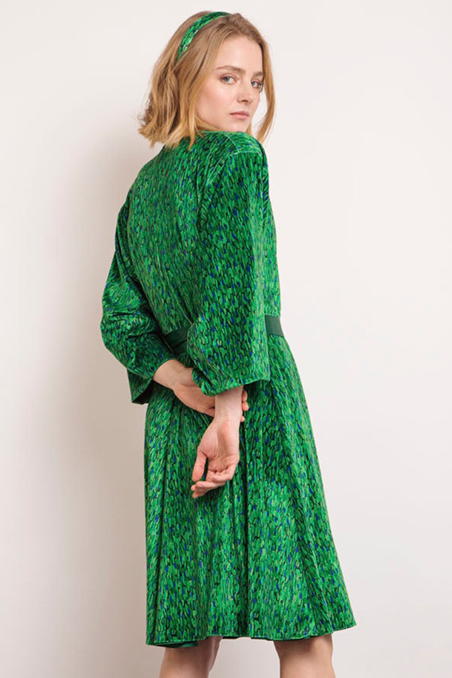Back view of model wearing reversible knee length velvet vibrant green print velvet kimono.