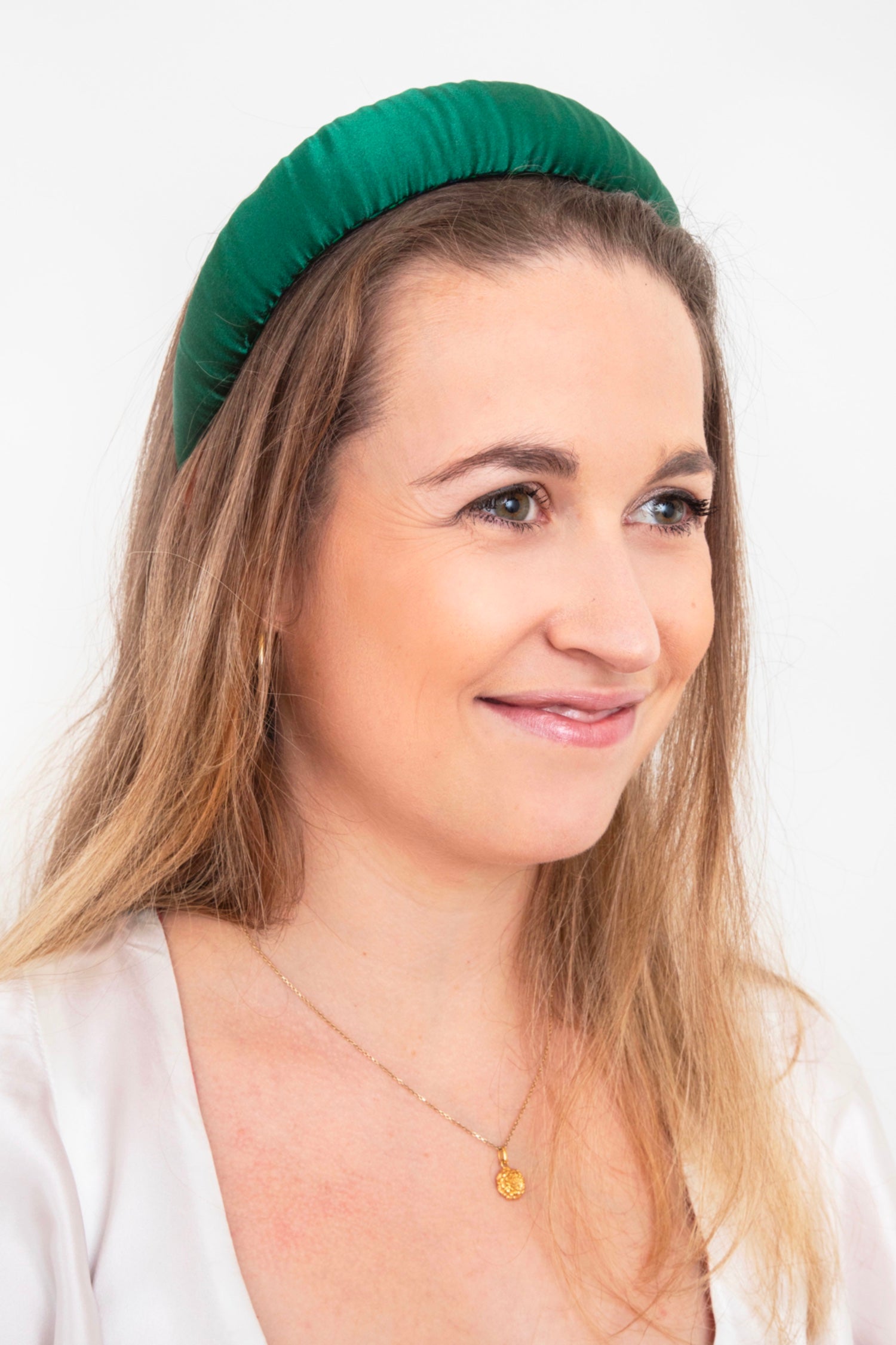 a dark green silk satin headband that is worn by a model elegantly