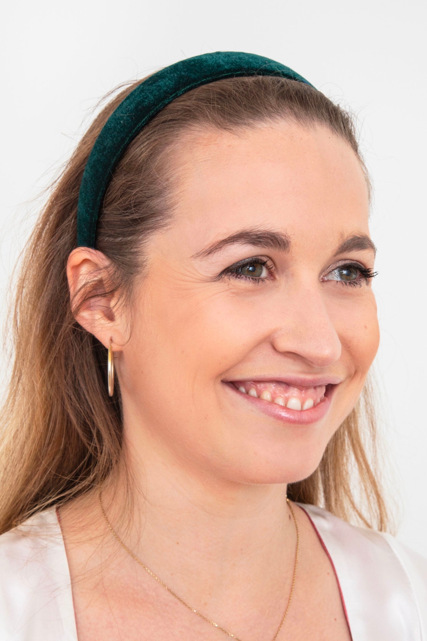 a luxurious dark green velvet headband worn by a model