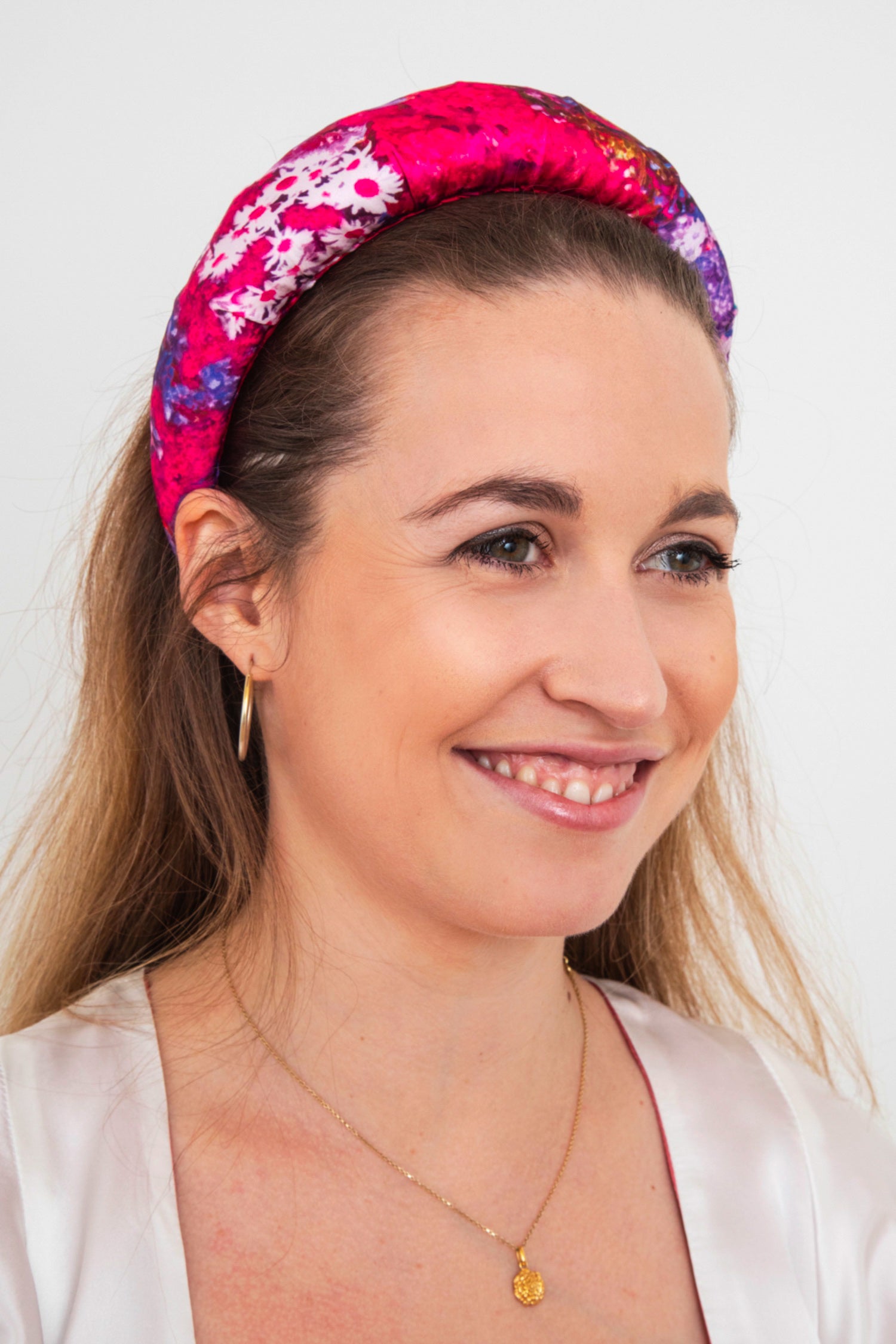 a vivid and vibrant purple and pink floral printed padded headband that gives you a pop of colour to your outfit