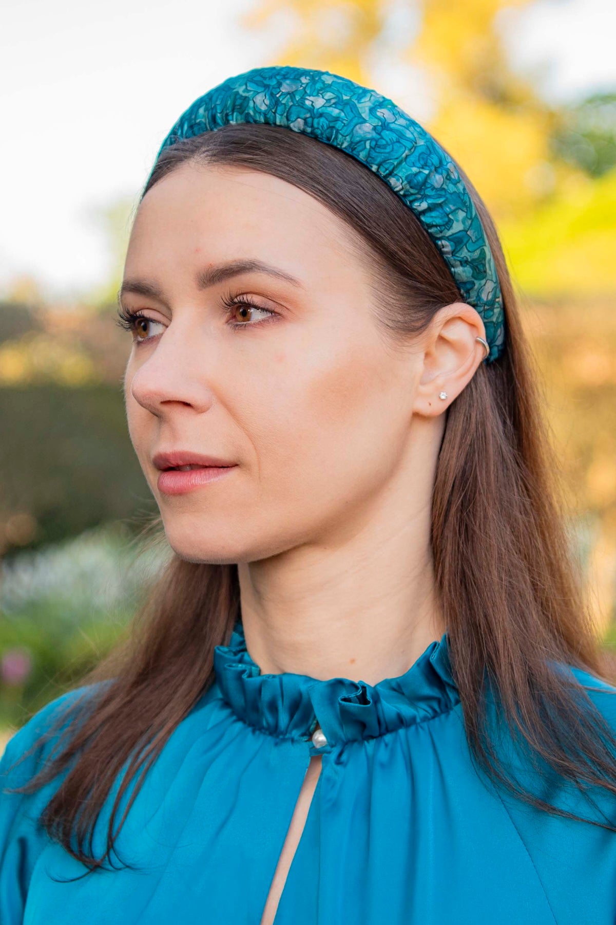 a teal printed silk satin padded headband worn by a model