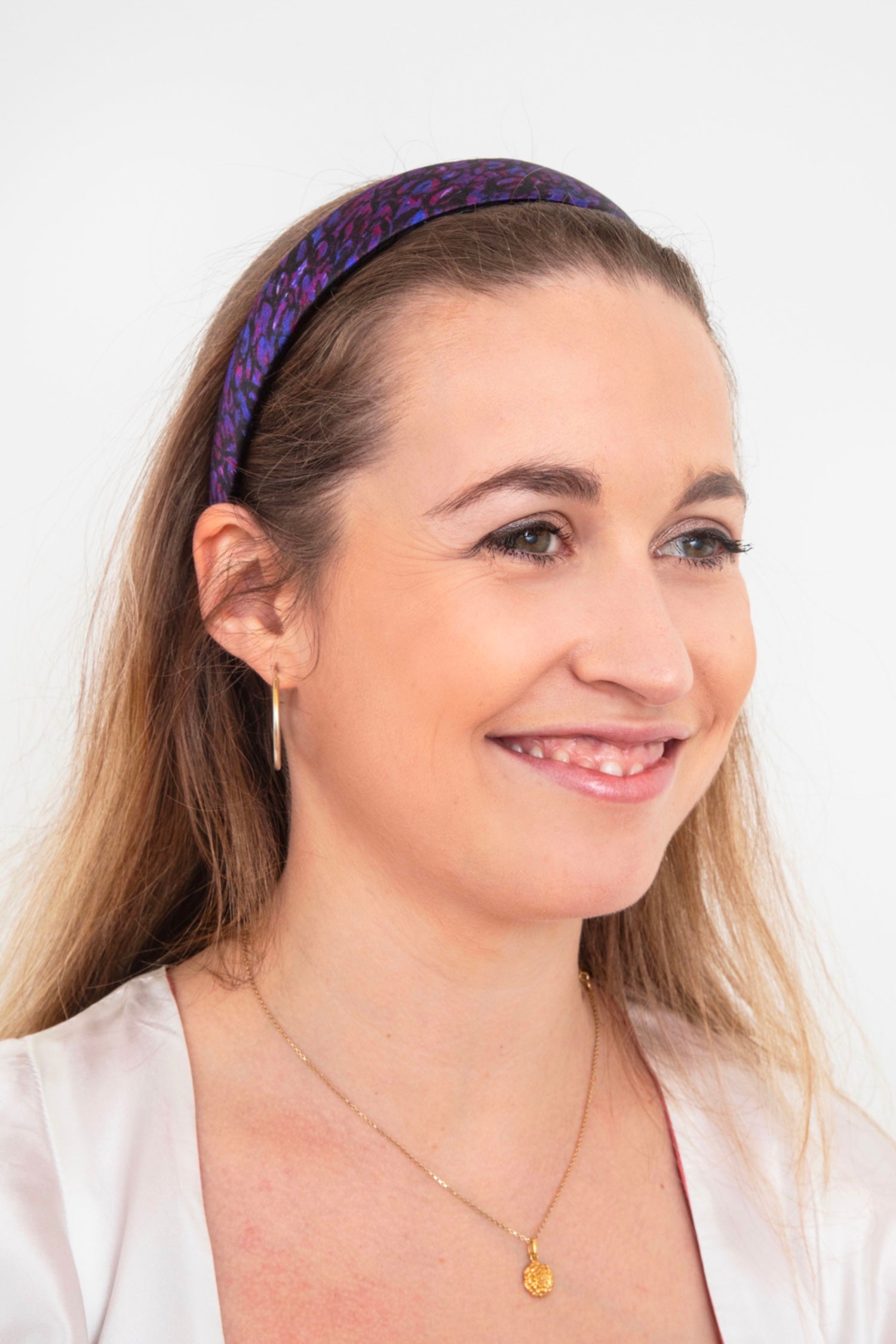 A silk headband in a dark purplesilk satin print. The print is easy to style due to a versatile range of purple and black colours, giving you a versatile styling option.