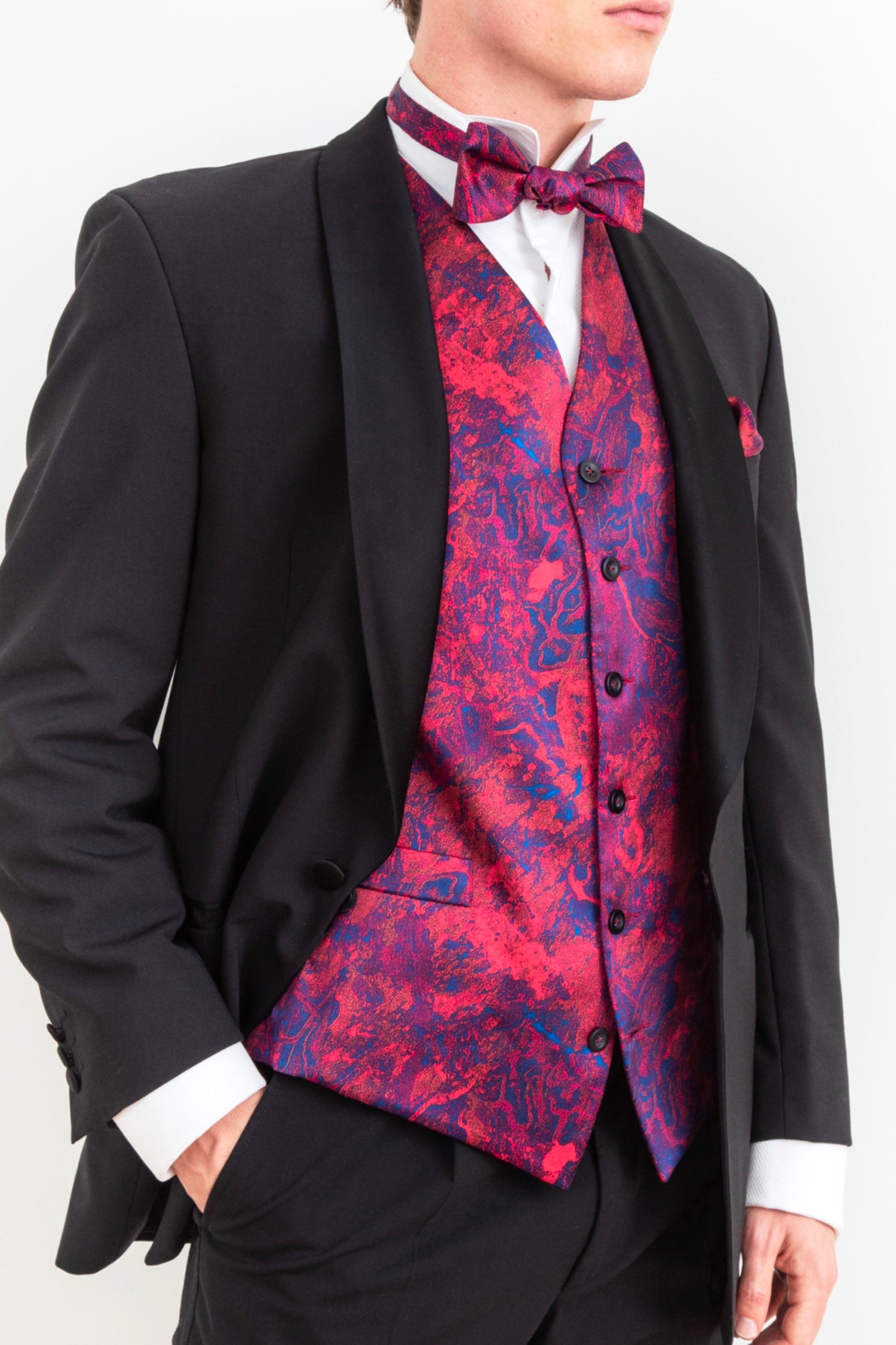 a colourful and stylish silk satin mens single breasted waistcoat worn by a gentleman in black tie with matching bow tie and pocket square