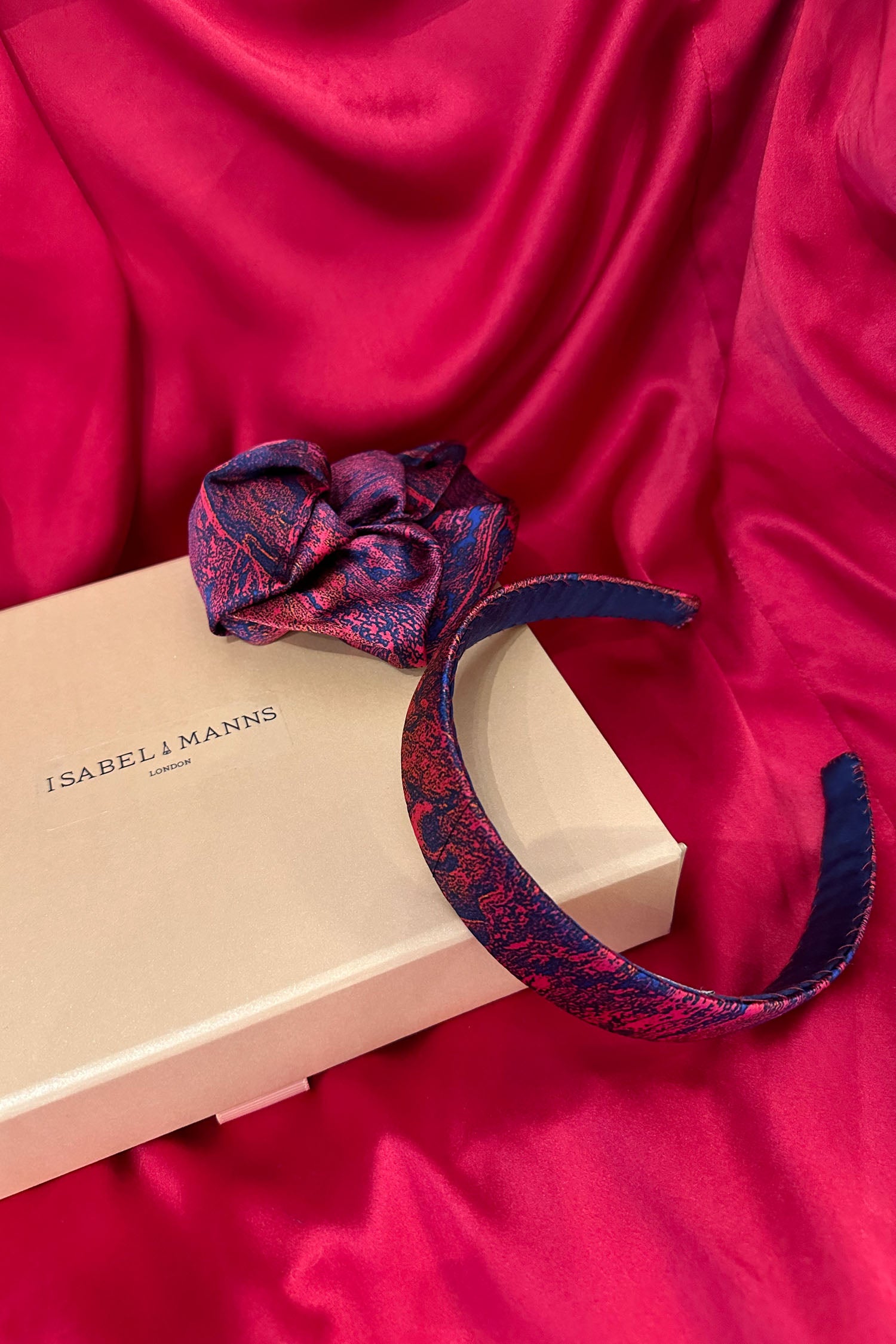 Red marble print silk satin headband with matching scrunchie and medium pink gift box bow tied ribbon.