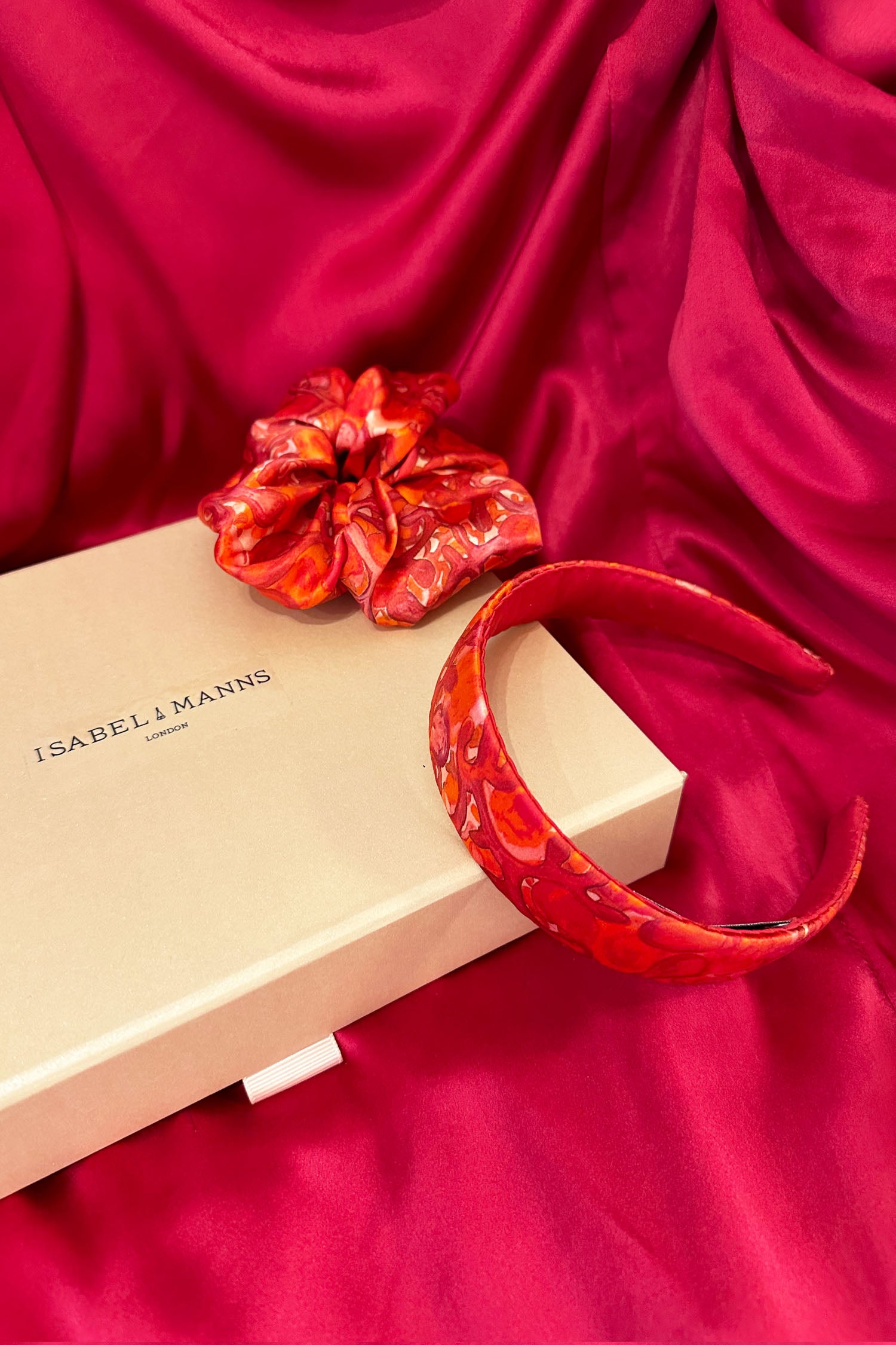 Red and pink swirl print silk satin headband with matching scrunchie and medium pink gift box bow tied ribbon.