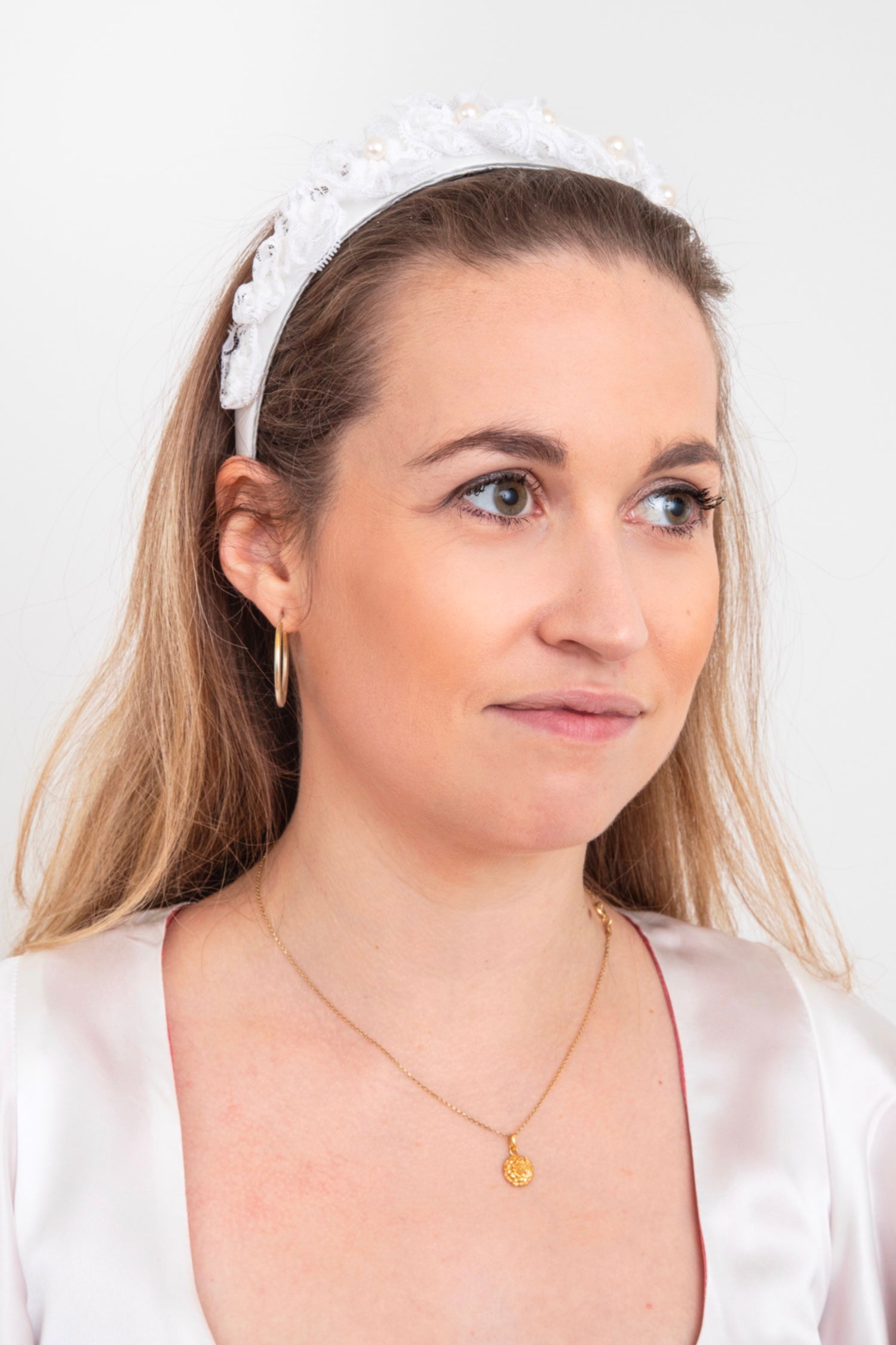 white headband with intricate lace and pearl detail hand stitched onto the headband sustainably in the UK
