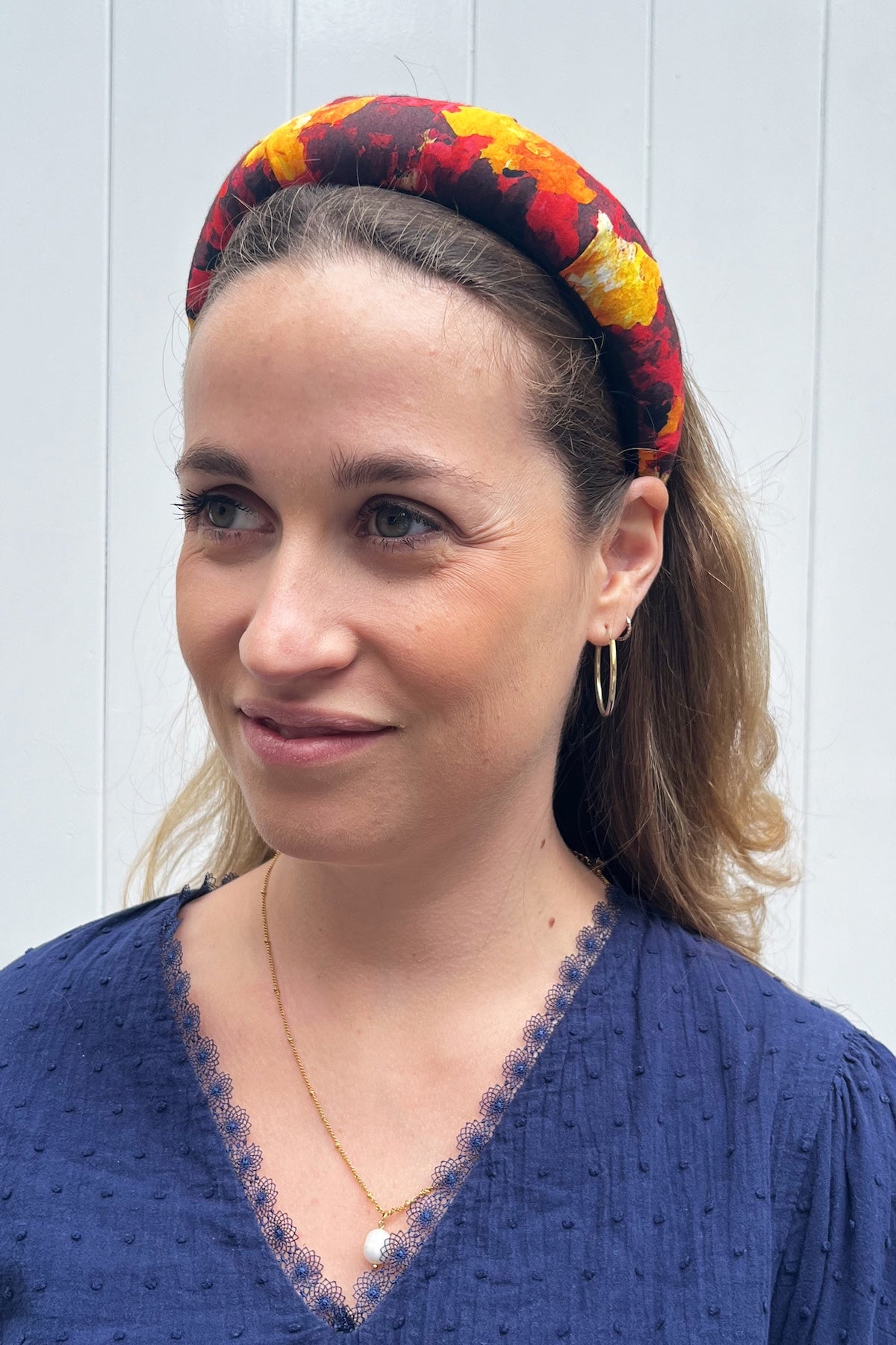 red, orange and black printed padded silk headband worn by model