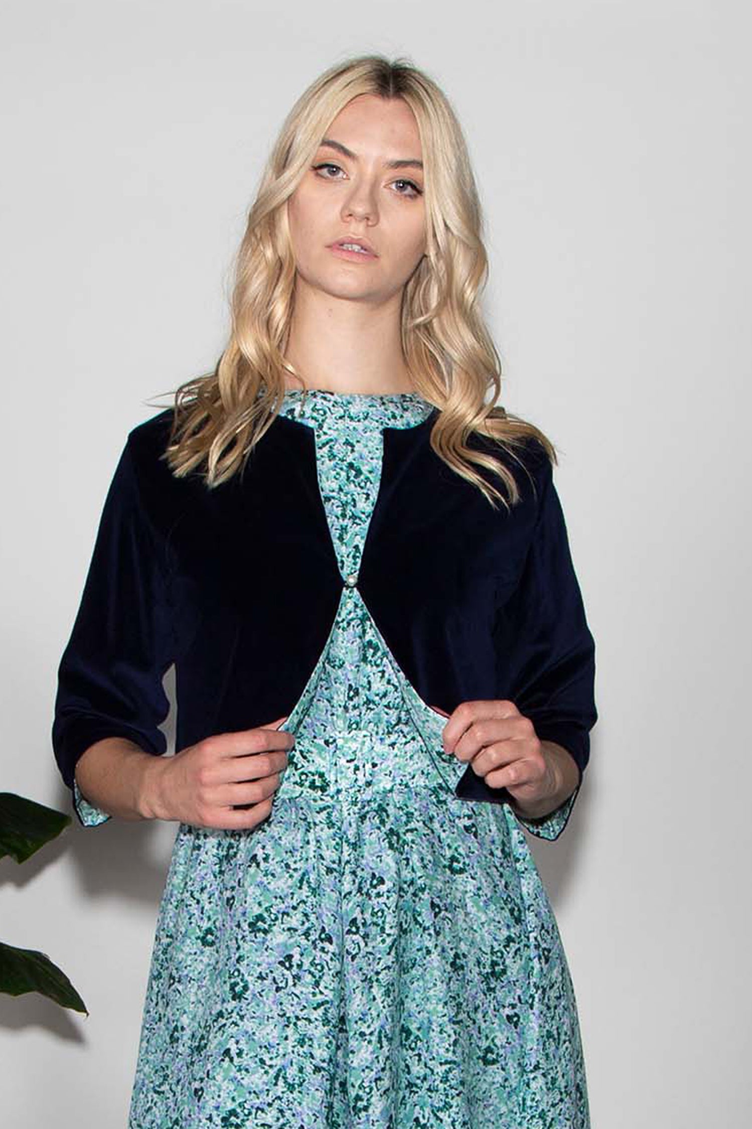 Model wearing reversible box shaped cropped navy velvet jacket, with pearl button, worn with matching Tabitha Dress.
