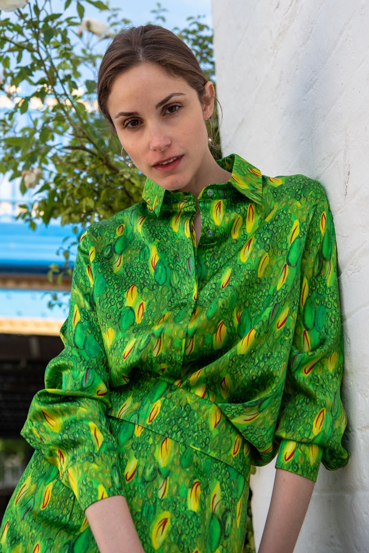 a women showing how to wear effortlessly our vivid green and yellow printed silk satin shirt with matching skirt