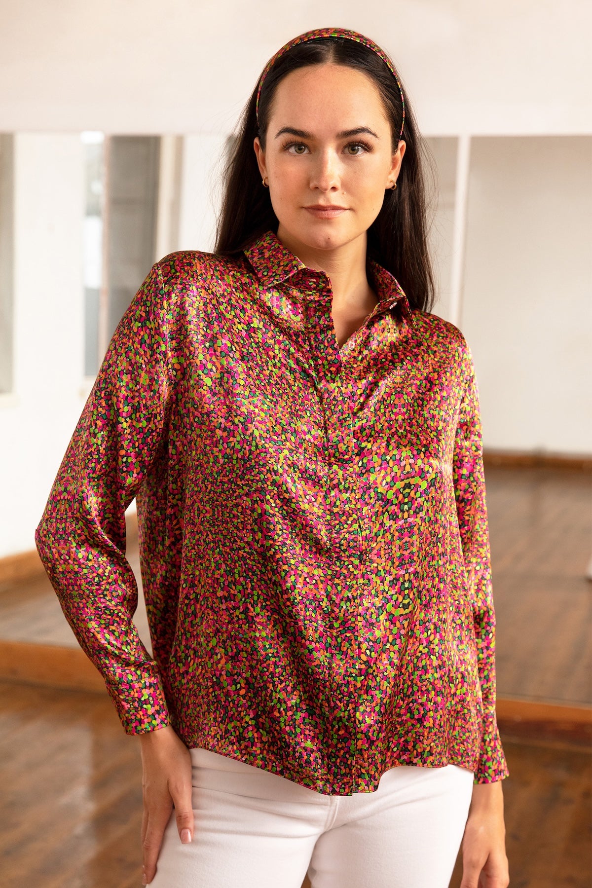 a dotted printed colourful silk satin shirt worn by a model with white jeans