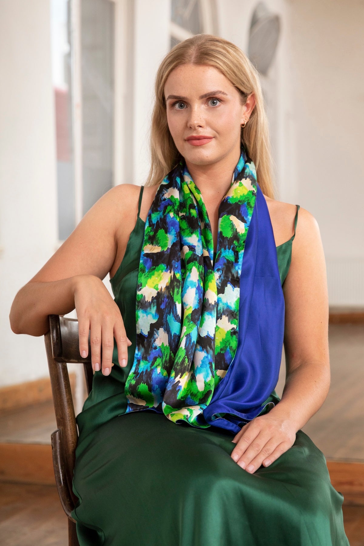 Model wearing long reversible silk satin scarf in vibrant multicoloured print and cobalt.