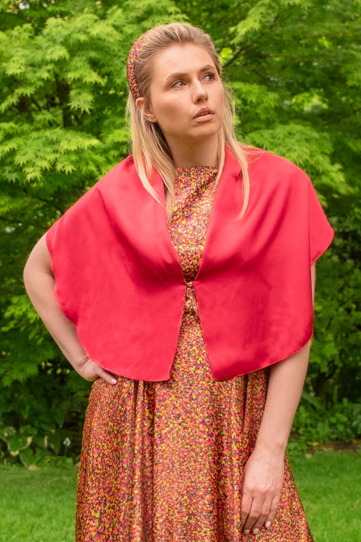 Model wearing reversible raspberry pink silk satin shawl with pearl fastener at the chest, with Neon Light padded headband and matching Victoria Gown.