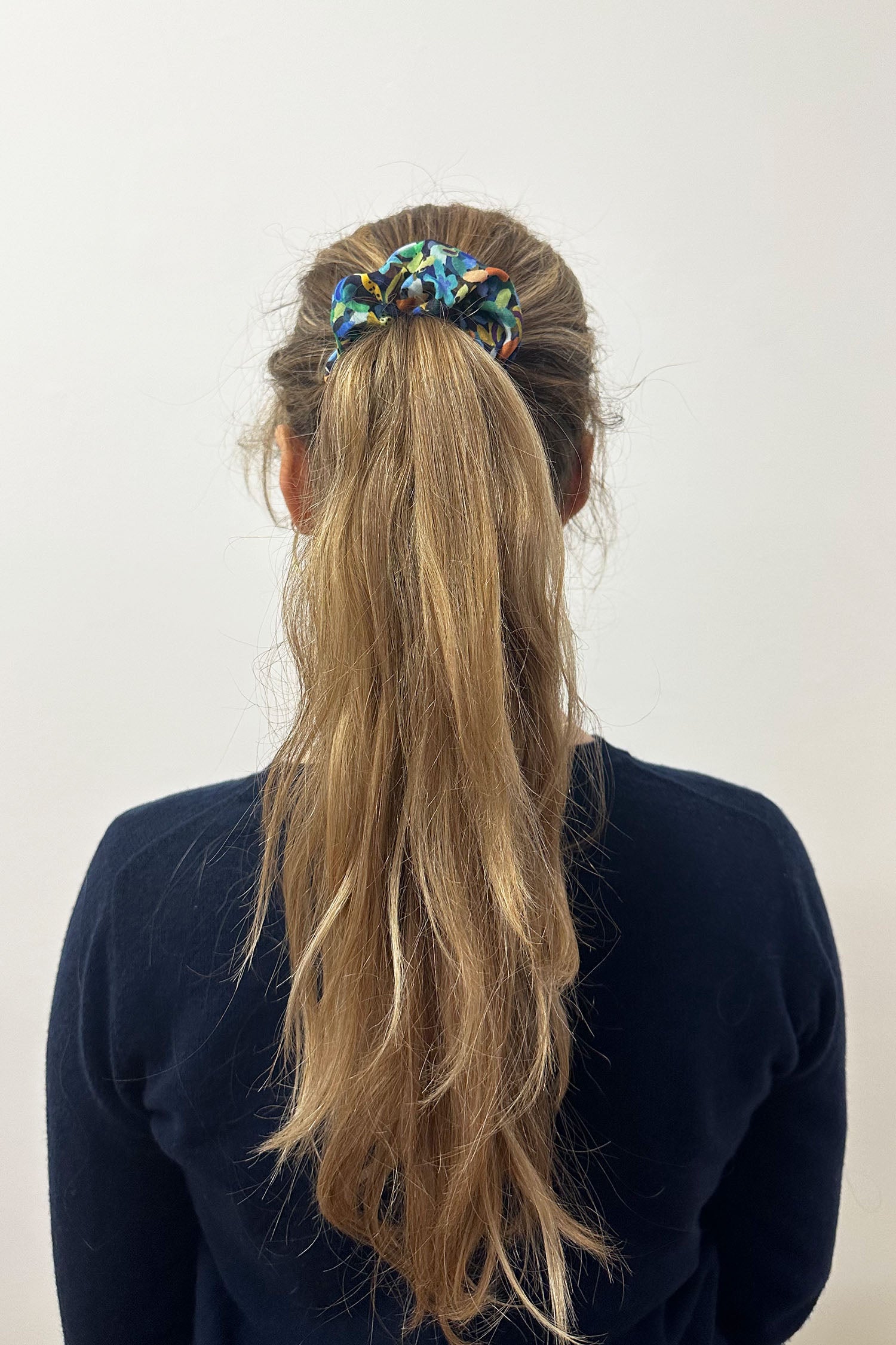 Model wearing green multicoloured print silk bamboo scrunchie.