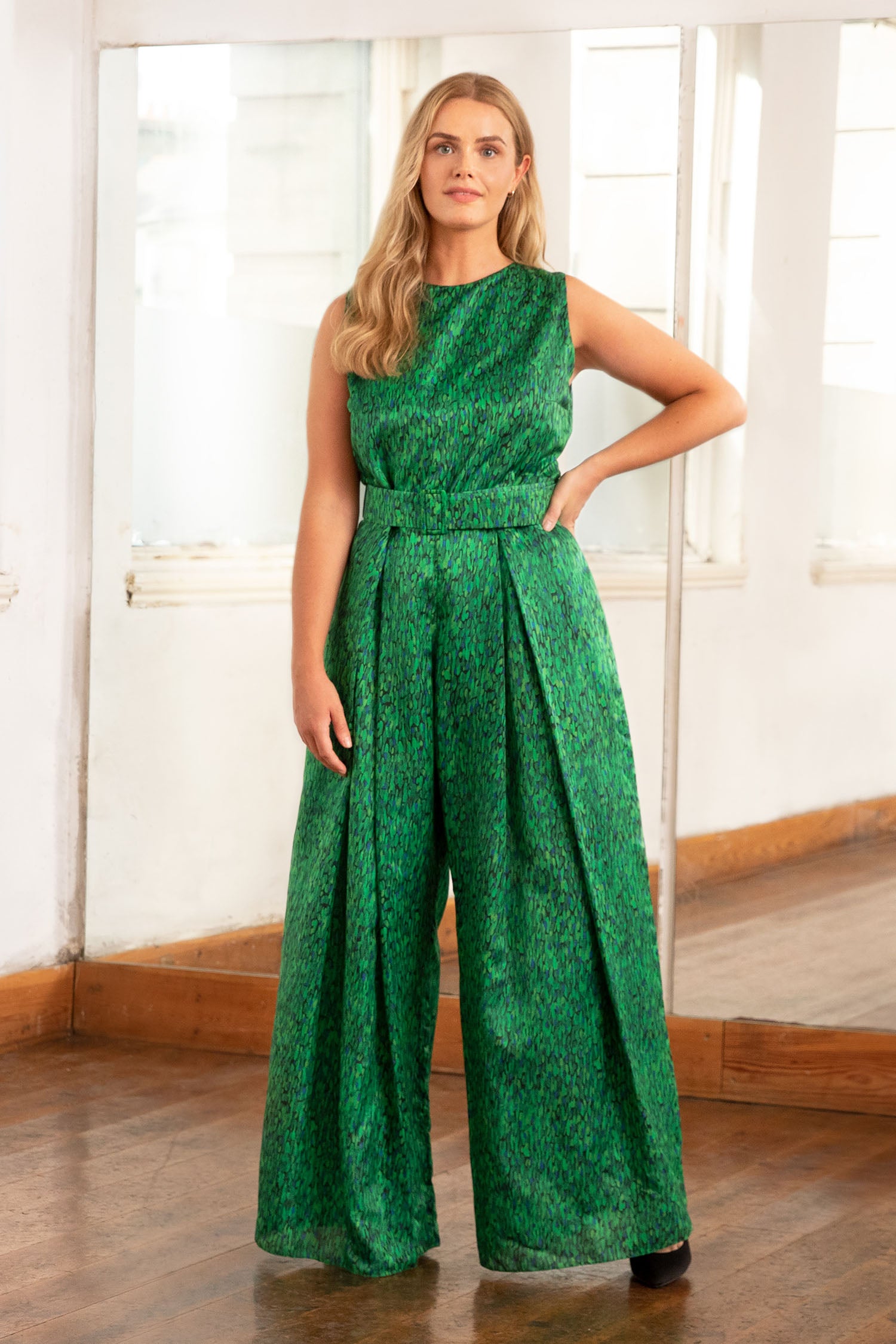An Isabel Manns sleeveless wide leg silk cotton jumpsuit and matching belt that comes in a vibrant green print.