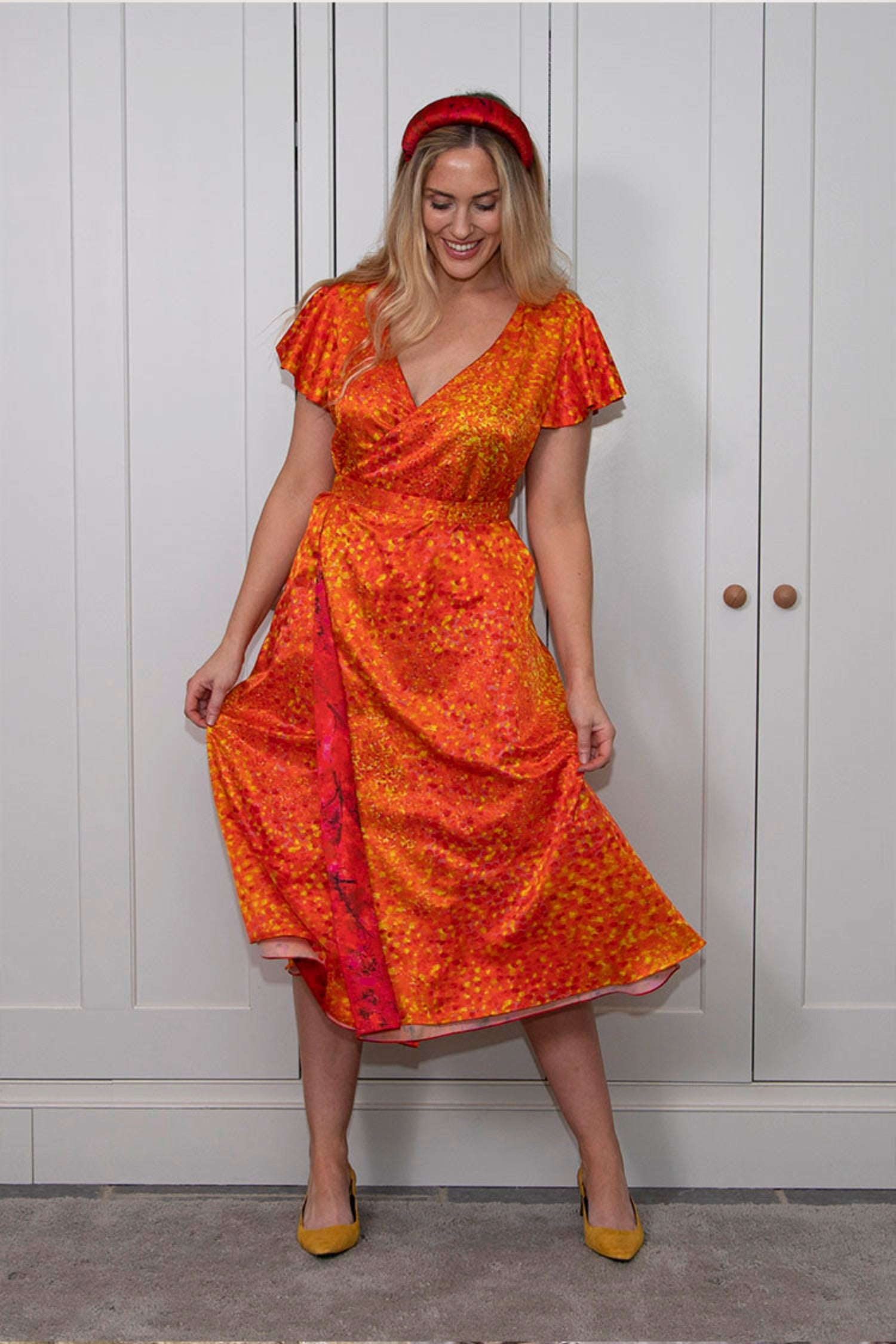 a reversible orange wrap dress elegantly worn by a model