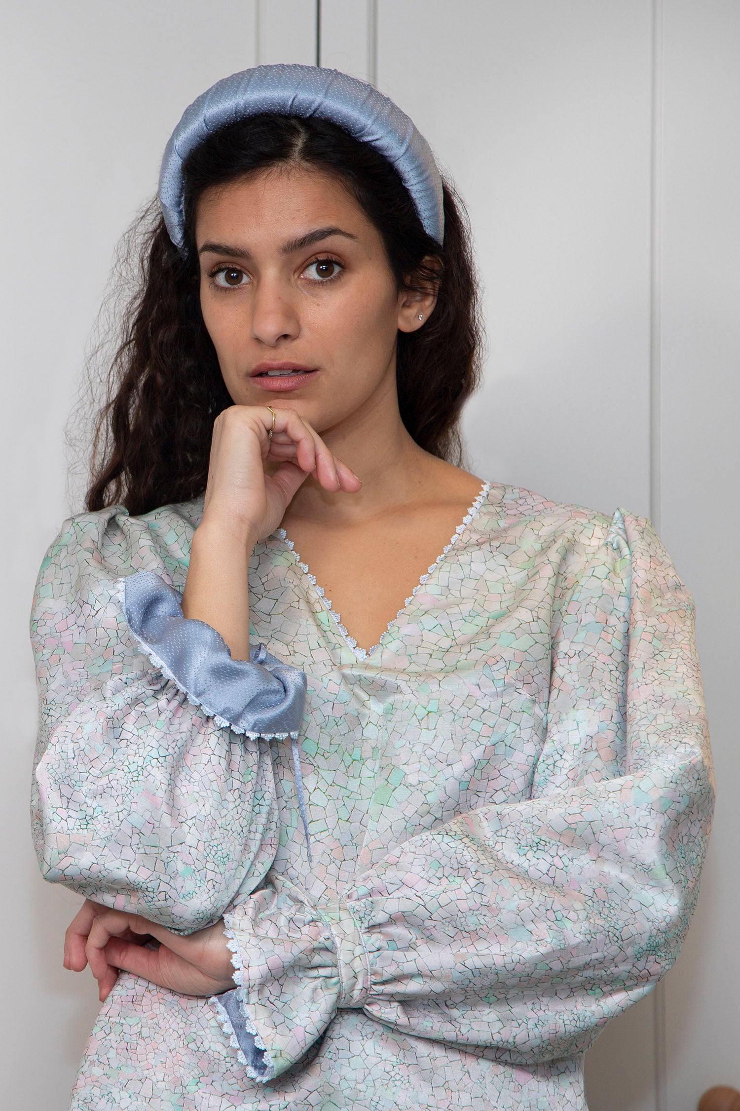 An Isabel Manns reversible long sleeve cotton top with peplum cuff in pastel blue print, worn with padded headband.