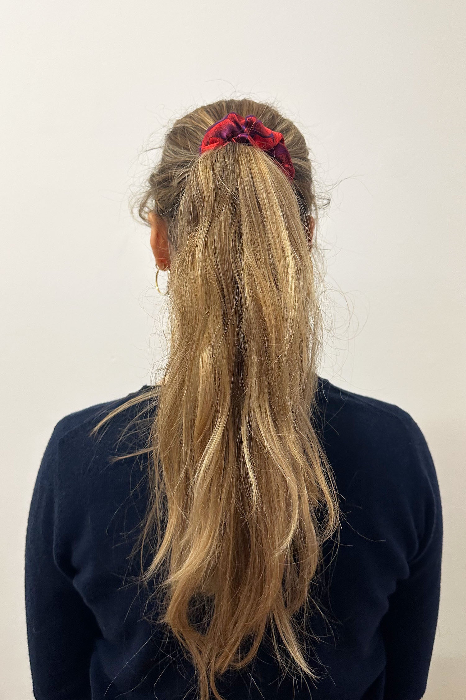 Model wearing vibrant red print silk satin scrunchie.