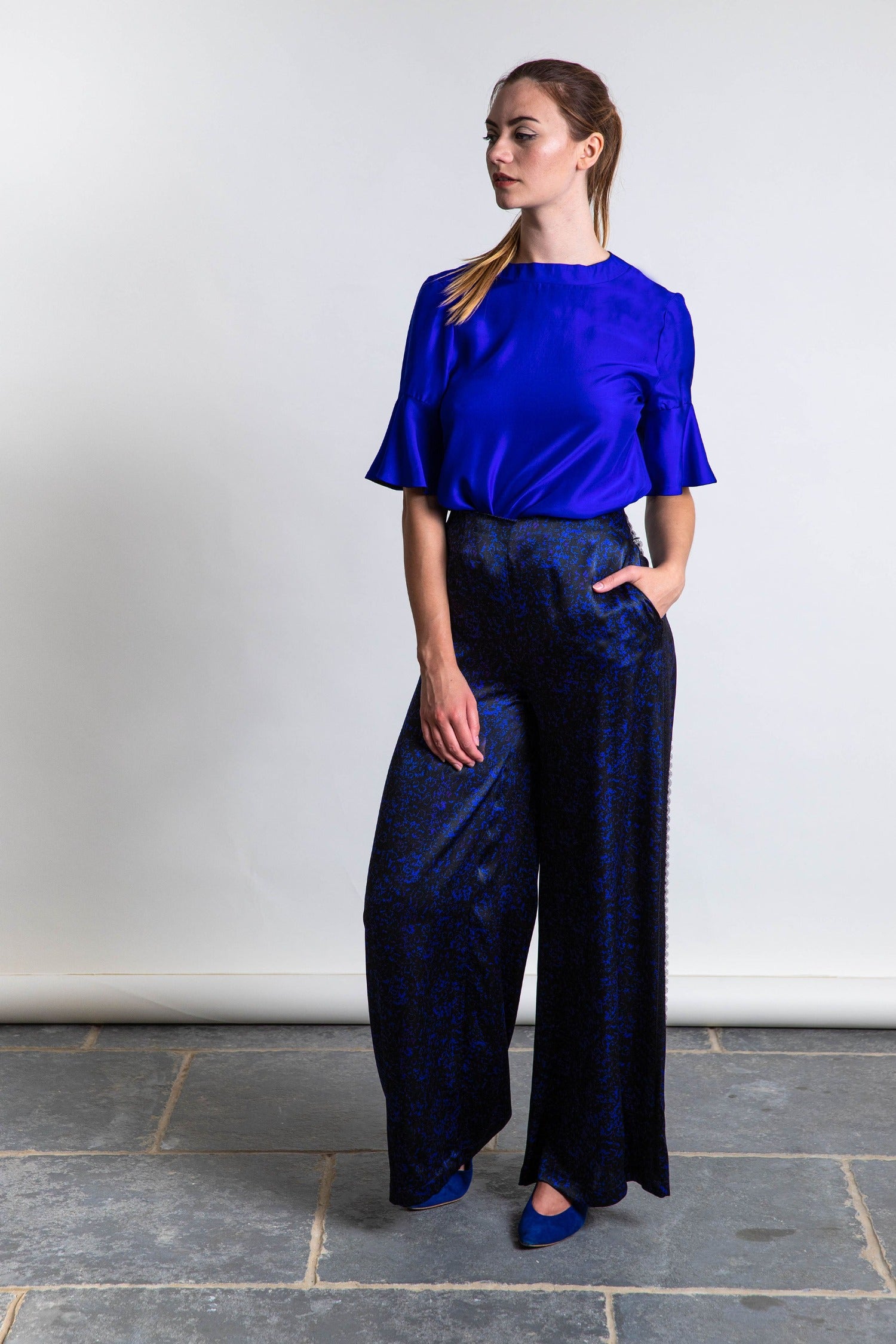 An Isabel Manns reversible peplum sleeve silk satin top with round neckline in cobalt, worn with matching Georgia Trousers.