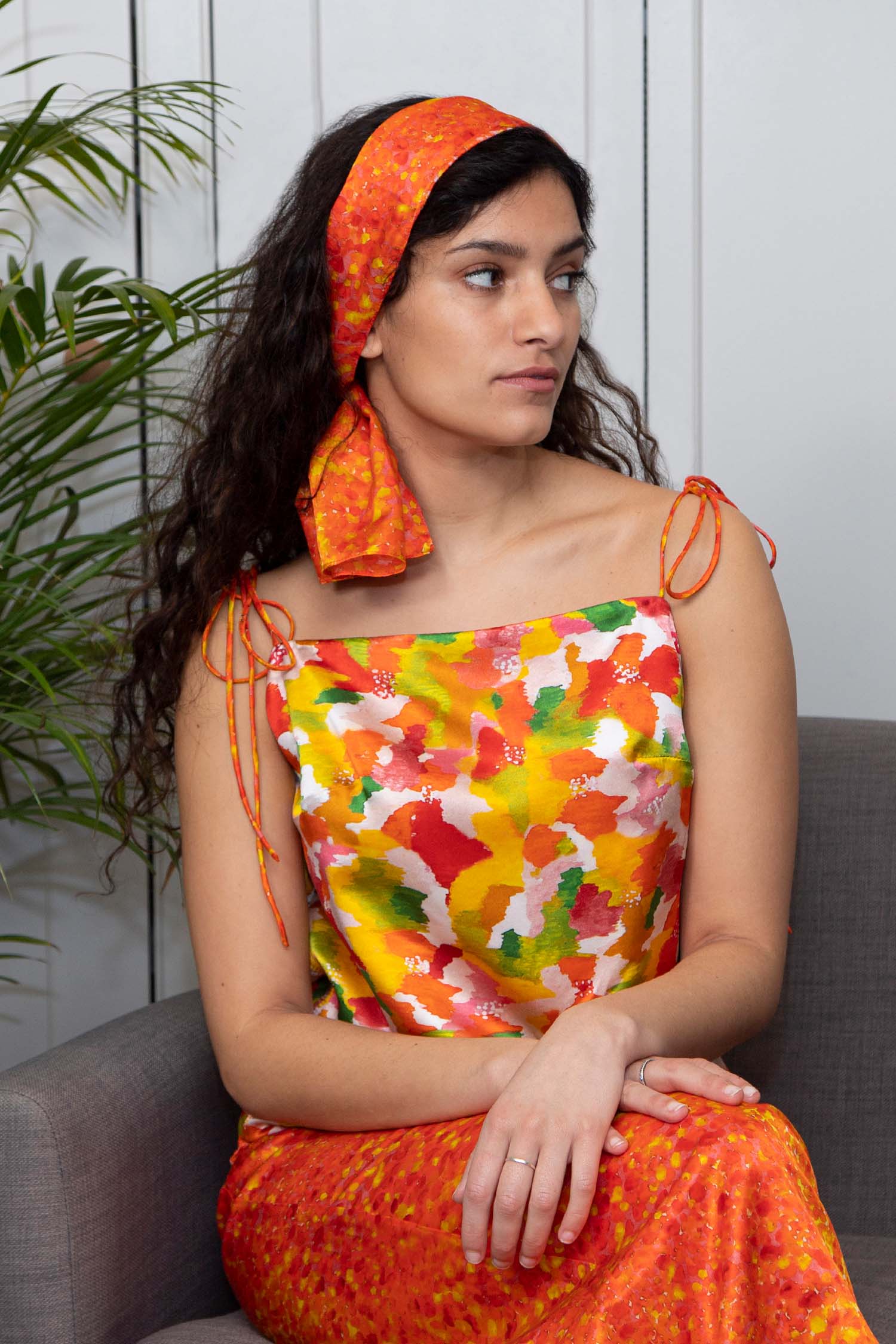 Reversible silk satin slip top with v-back neckline in vibrant yellow print, worn with matching scarf.