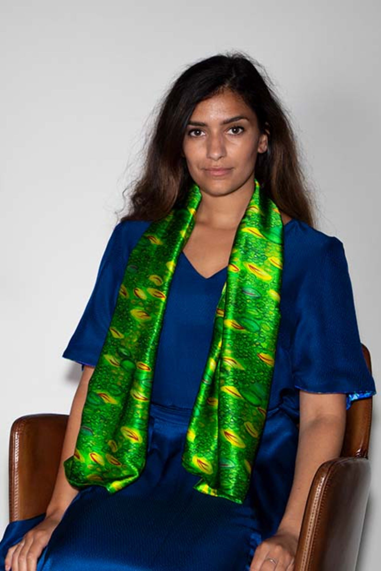 Model wearing long double-sided silk satin scarf in green and yellow print.