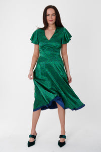 A green printed silk satin dress with short sleeves and a v-neckline