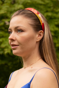 Multi coloured vibrant printed cotton headband modelled by a beautiful model to show its versatility