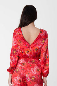Back view of long sleeve silk satin top with low back in coral floral print.
