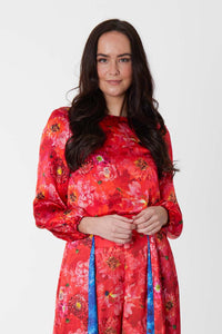 An Isabel Manns long sleeve silk satin top with low back in coral floral print.