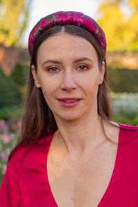 a dark pink floral printed silk padded headband worn by a model
