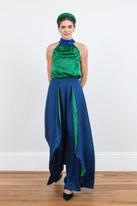 Model wearing an Isabel Manns wide leg wrap around style silk viscose trousers in navy and contrasting vibrant green print lining, worn with matching halterneck Sophie Top in vibrant green print and padded headband.