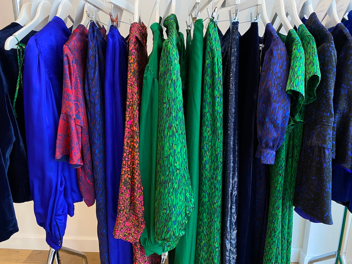 A rail showcasing multiple items of silk clothing in a variety of silk prints at the Isabel Manns London shop