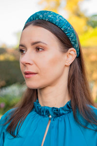 a teal printed silk satin padded headband worn by a model