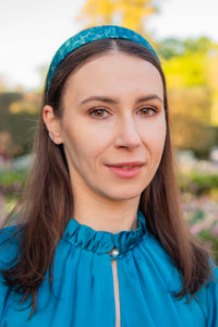 a teal silk printed headband worn by a model