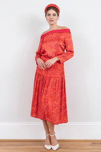Model wearing a-line midi silk bamboo skirt with an extra wide waistband and gathered detail from hips down in vibrant red swirl print, worn with matching boat neck Hayley Top and padded headband.