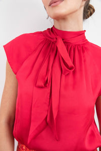 Front bow tie detail of reversible halter neck silk satin top with tie collar and cap sleeves in Raspberry Pink.