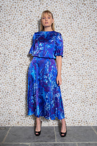 Model wearing reversible voluminous a-line midi silk satin blue water print skirt, worn with matching high neck Rosie Top.