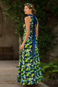 back view of colourful vibrant printed silk satin halter neck dress with a cobalt collar and matching tie belt worn by a model