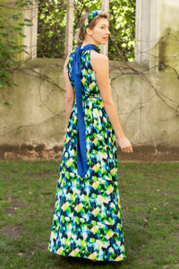 back view of colourful vibrant printed silk satin halter neck dress with a cobalt collar and matching tie belt worn by a model