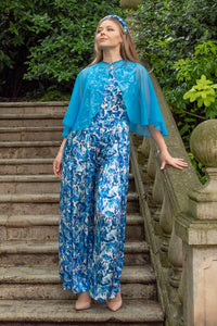 An Isabel Manns sleeveless wide leg silk satin jumpsuit and matching belt that comes in a vibrant blue print, worn with matching Turquoise chiffon shawl.