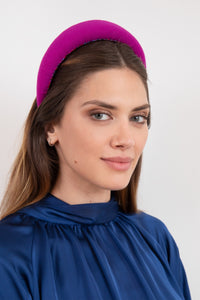 Vibrant magenta coloured padded headband elegantly on a models head