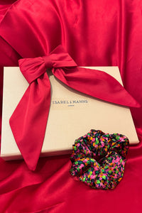a gift box featuring a pink bow and printed silk scrunchie