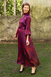 Red marble printed silk satin halter neck dress with keyhole neckline, long elasticated sleeves and a tie belt worn by a model