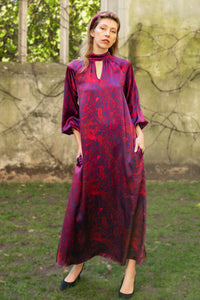 Red marble printed silk satin halter neck dress with keyhole neckline and long elasticated sleeves worn by a model