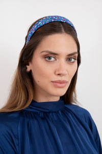 A pretty dotted printed headband comprising of blues and pinks that gives you colour worn by a model that is sustainable