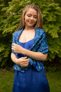 Model wearing long reversible silk satin scarf in blue floral print and cobalt, with cobalt Alice dress.