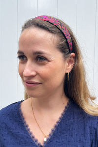 A unique pink and brown silk headband worn by a model that will add a touch of colour to your outfit