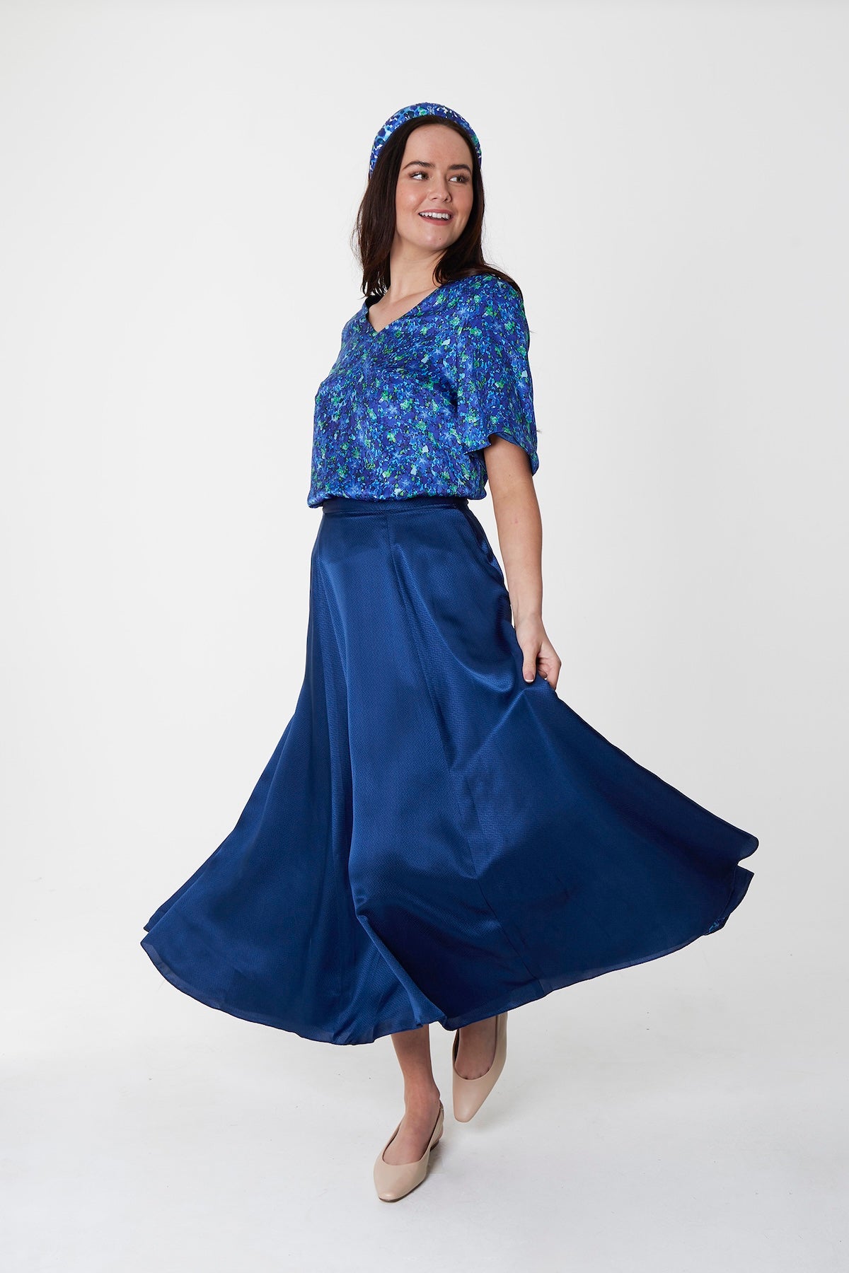 Reversible v-neck silk satin top with elbow length sleeves in blue floral print, worn with matching Emma skirt navy and padded headband.