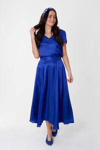 Model wearing reversible voluminous a-line midi silk satin vibrant cobalt skirt, worn with matching v-neck Eleanor Top and Violet Marinace padded headband.