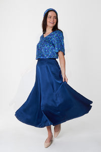 Model wearing reversible voluminous a-line midi silk satin navy skirt, worn with Eleanor Top in Aqua Flora and padded headband.