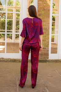 a back view of a red printed silk fire ocean trousers